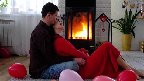 Man and woman in love date at home are sitting near the fireplace stove ...