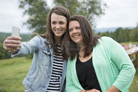 两个女朋友在户外使用智能手机进行自我肖像高清图片下载-正版图片501844294-摄图网