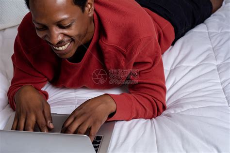 美国年轻人在床上用笔记本电脑高清图片下载-正版图片303551675-摄图网