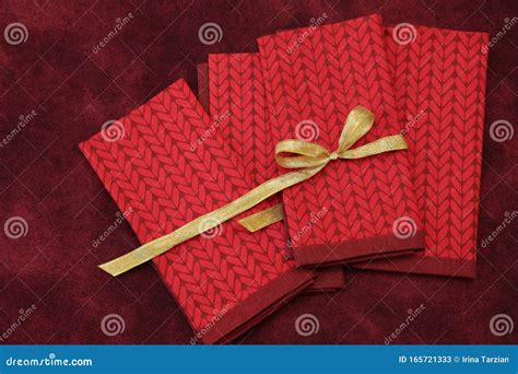 Red Fabric Napkins with a Gold Ribbon on a Red Tablecloth. Holiday ...