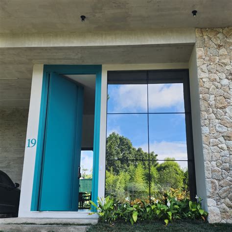 Porta pivotante em ACM verde finland com puxador cava e dupla vedação ...