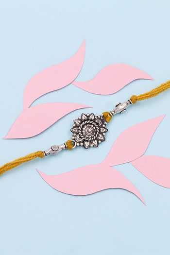 Buy Silver Carved Floral Motif Yellow Thread Tie-up Rakhi by Sangeeta ...