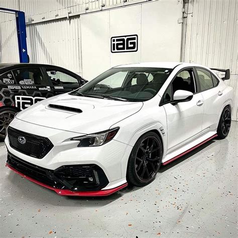 White Subaru WRX Parked in Garage with Red Rims