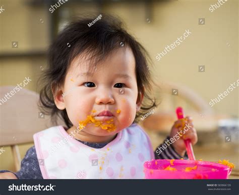 Baby Girl Eating Mashed Sweet Potatoes Stock Photo 583866139 - Shutterstock