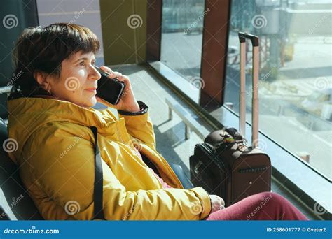 Mature Brunette Woman Sitting in the Airport Lounge and Speaks on the Phone Stock Image - Image ...