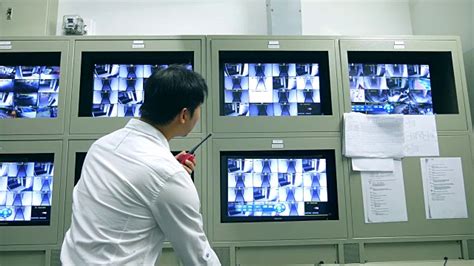 一名男性保安在一间有很多监视器的办公室里从监控摄像头里读取数据视频素材_ID:VCG42N1304911437-VCG.COM