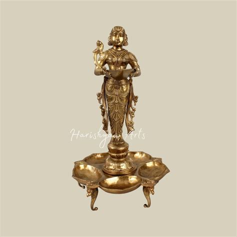 17" Graceful Deepalakshmi Holding a Lamp on a Tray of Lamps