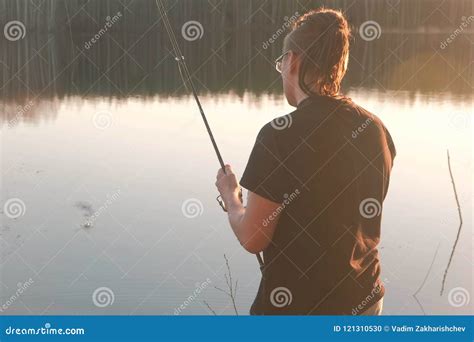 Fisherman on the Pond. Young Guy with Dreads in Glasses in a T-shirt ...