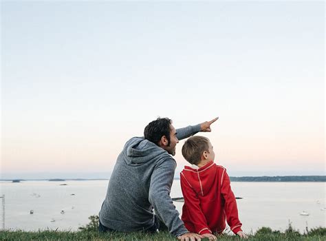 "Father Sitting Together With Son Pointing Into The Sky" by Stocksy ...
