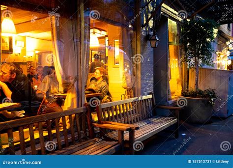 Street Scene with Restaurant, Lights, and People at Night Seen from ...