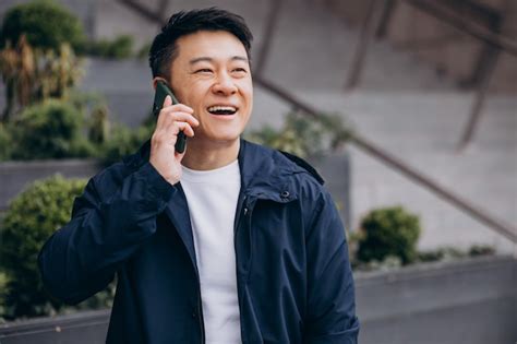 Korean guy using phone outside thes treet | Premium Photo