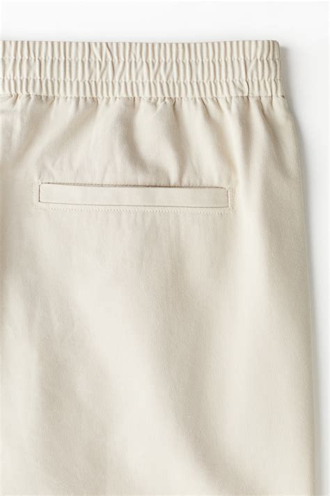 Relaxed Fit cotton-blend twill trousers - Light beige - Men | H&M IN
