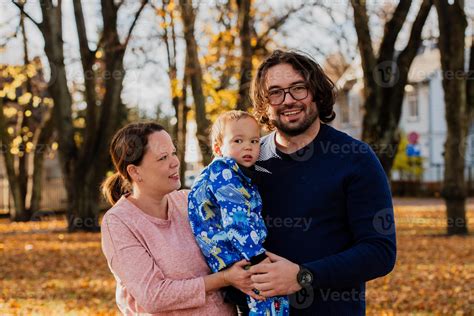 en un soleado otoño día en el parque, un madre y padre cariñosamente ...