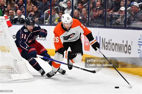 Sean Walker of the Philadelphia Flyers battles to keep the puck from ...