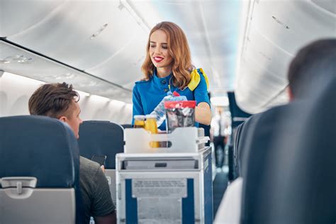 Flight attendant serving food and drinks to passengers on board - AirlineCareer.com