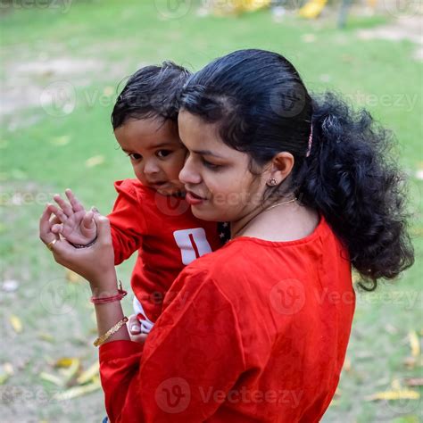 Loving mom carrying of her baby at society park. Bright portrait of ...