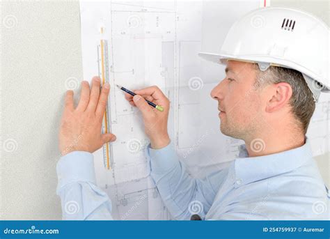 Man Measuring Plans Pinned To Wall Stock Image - Image of design, blueprints: 254759937