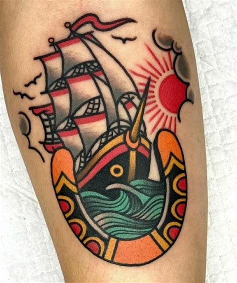 a tattoo on the leg of a person with a ship and sun in the background