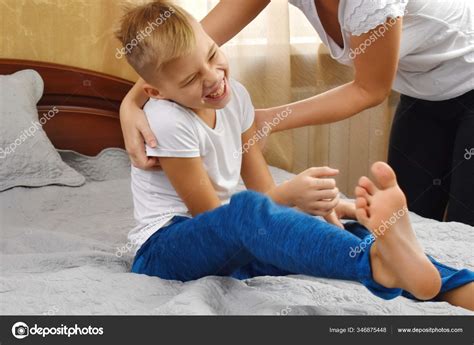 Mother tickling son. The parent teases the child. Fun games with mom ...