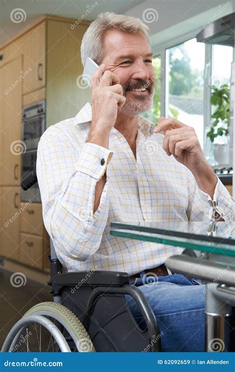 Disabled Man in Wheelchair Making Call on Mobile Phone at Home Stock ...
