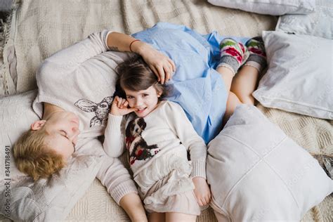 Mother and daughter cuddling on a bed in a kids room