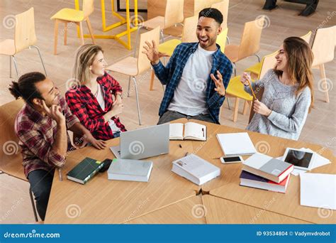 Happy Students Sitting in Library Talking with Each Other. Stock Photo ...