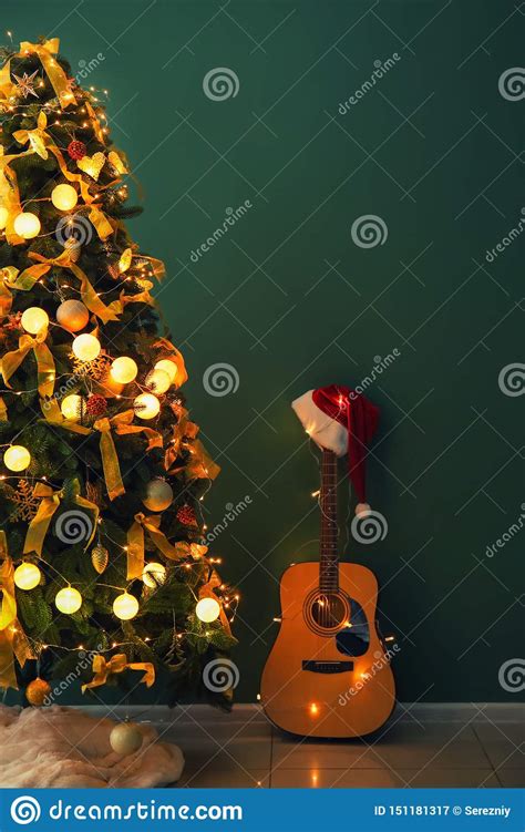 与吉他的美丽的装饰的圣诞树在颜色墙壁附近户内 库存图片. 图片 包括有 与吉他的美丽的装饰的圣诞树在颜色墙壁附近户内 - 151181317
