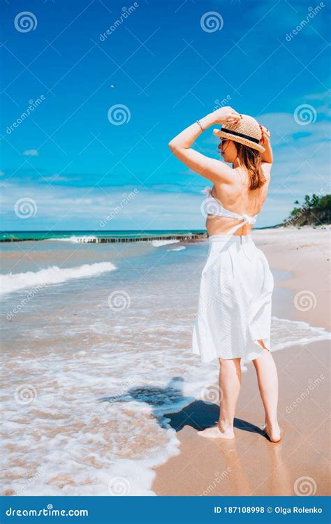 Beautiful Woman Wearing Straw Hat, White Swimsuit and Skirt Walking ...