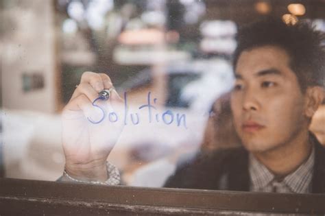 Businessman writing a business solutions concept on window. | Premium Photo