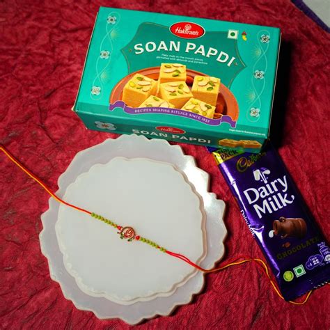 Send Flute Rakhi with Soan Papdi and Dairy Milk Online