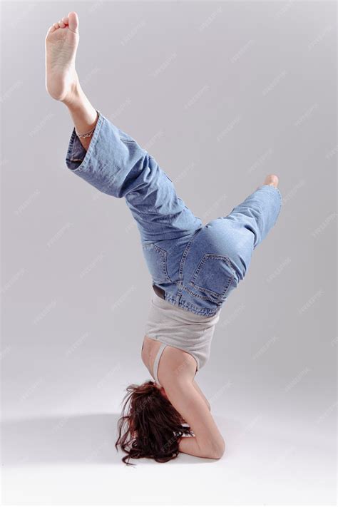 Premium Photo | Fit woman acrobat in jeans stretching her legs. acrobat ...