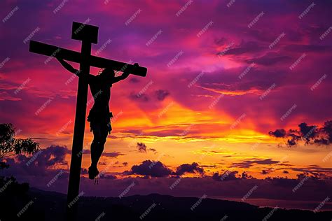 A cross with jesus hanging on the cross with a sunset in the background ...
