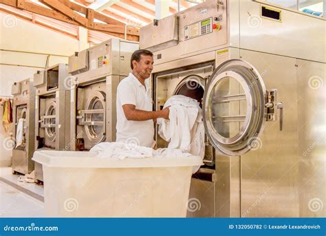 Worker in Uniform Putting Bed Sheet into Washing Machine Editorial ...