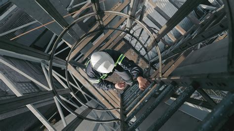 Industrial Worker Climbing Ladders Up. Top view, Worker with hard hat ...
