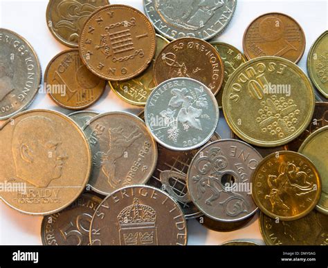 Coins on white background different countries currency, Norwegian krone øre, UK, Portuguese ...