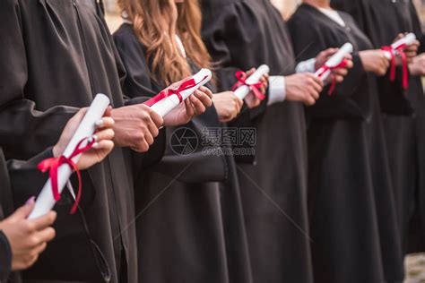 穿着学术礼服的成功毕业生拿着文凭高清图片下载-正版图片502616188-摄图网