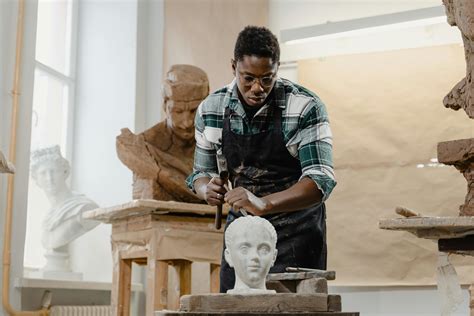 A Sculptor Using a Hammer and a Chisel · Free Stock Photo