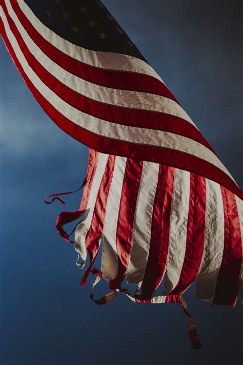 A large american flag flying in the sky photo – Free American flag ...
