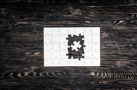 White started puzzle with uncompleted center on dark wooden background ...