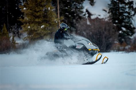 Rider riding up a snowy mountain on the 2027 Ski-Doo Summit