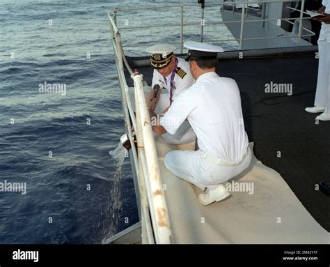 Chaplain (CAPT.) Lester L. Westling Jr. pours the ashes of the deceased ...
