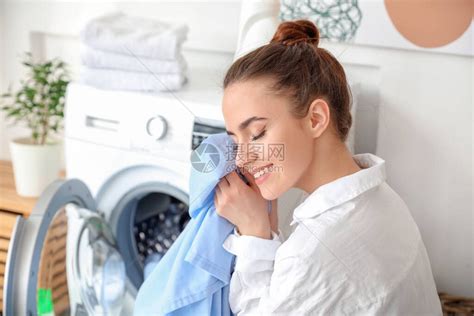 美丽的年轻女子在家里洗衣服高清图片下载-正版图片504382511-摄图网