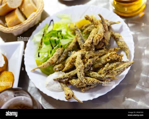 Fried anchovies with sauce and herbs. Spanish cuisine Stock Photo - Alamy