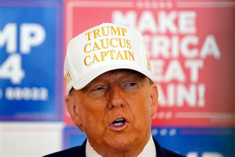 Trump, with his family watching, raises his right hand and places his left hand on the Bible as he t