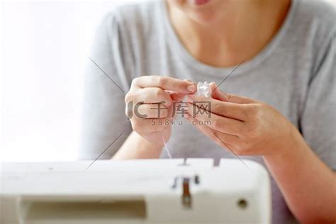 人、针线活和裁缝概念-在工作室用线轴和缝纫机裁缝女人。高清摄影大图-千库网