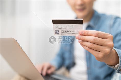 家居男子使用电脑手拿银行卡特写高清图片下载-正版图片500709035-摄图网