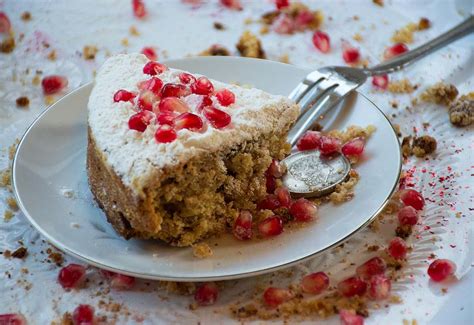 side view of Vaselopita - Greek New Years Cake dusted with powdered sugar with a slice cut out of it