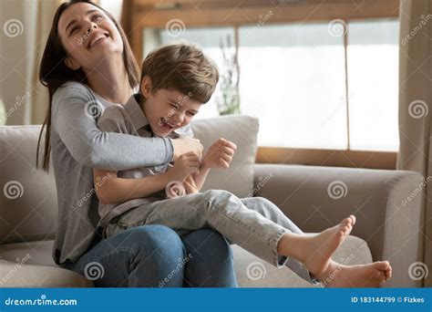 Happy Young Mom and Little Son Cuddling and Laughing Stock Image ...