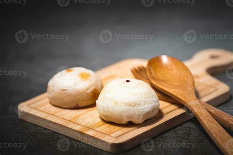 Traditional Chinese pastry with wooden spoon on plate against dark ...