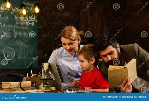 Pretty Teacher Helping Pupil in Classroom at the Elementary School, Tutor Asks the Tutee To Find ...